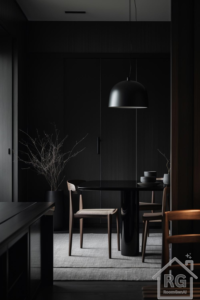 A dark Japandi dining room with matte black surfaces, warm wood tones, and minimal decor, illuminated by a soft overhead light.