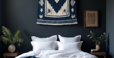 A serene dark boho bedroom featuring deep charcoal blue walls, white linen bedding, and a large blue and white woven tapestry above the bed. Rustic wooden nightstands with green plants flank the bed, and a wooden bench sits at the foot, creating a cozy and natural aesthetic.
