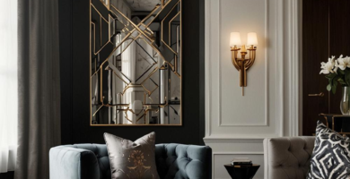 A sleek and contemporary living room featuring a teal velvet armchair, a light grey tufted sofa, and a round marble coffee table. A large gold Art Deco mirror hangs on a dark accent wall, complementing the luxurious and inviting ambiance of this modern living space.
