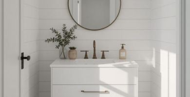 A bright Scandi Modern powder room featuring white shiplap walls, a floating white vanity with brass hardware, a round brass mirror, and two brass pendant lights. The room is anchored by a dark patterned tile floor, creating a stylish and functional space.
