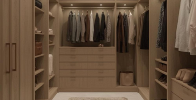 A spacious and well-lit walk-in closet featuring light wood built-in cabinetry, open shelving, hanging rods, and a large central drawer unit. A soft beige shag rug covers the light-colored floor, enhancing the luxurious feel of this organized dressing room.